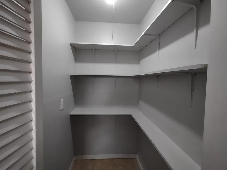 Large pantry with plenty of shelves and power outlet.