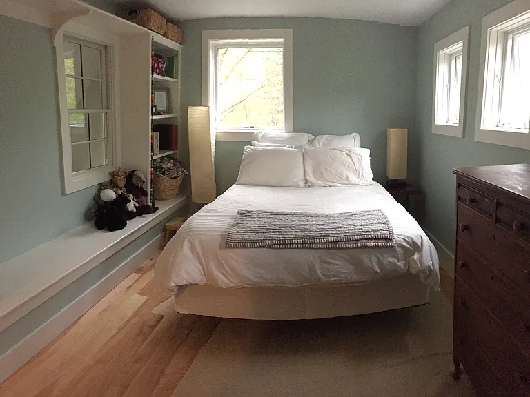 Bedroom with queen bed, custom-built bookshelves, and custom-designed closet
