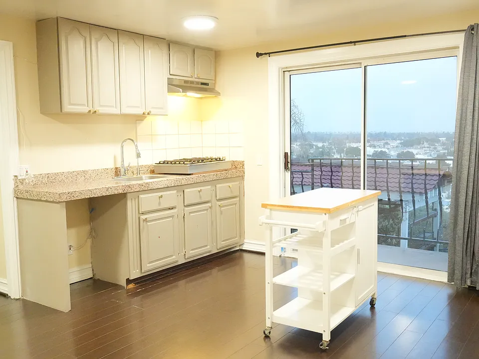 Kitchen with kitchen island overlooks the Los Angeles City. Next to the kitchen is an ample amount of space to put dining table