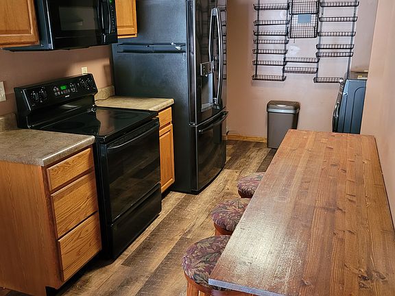 Kitchen with smooth top electric range, over the range microwave, 25 cub French door refrigerator, spice rack, garbage disposal, dishwasher full size washer dryer and bar with 4 stools.