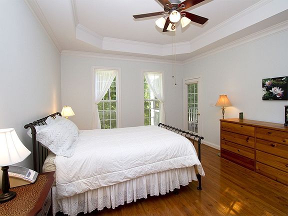 The soothing master bedroom overlooks a wooded buffer & has access to porch.
