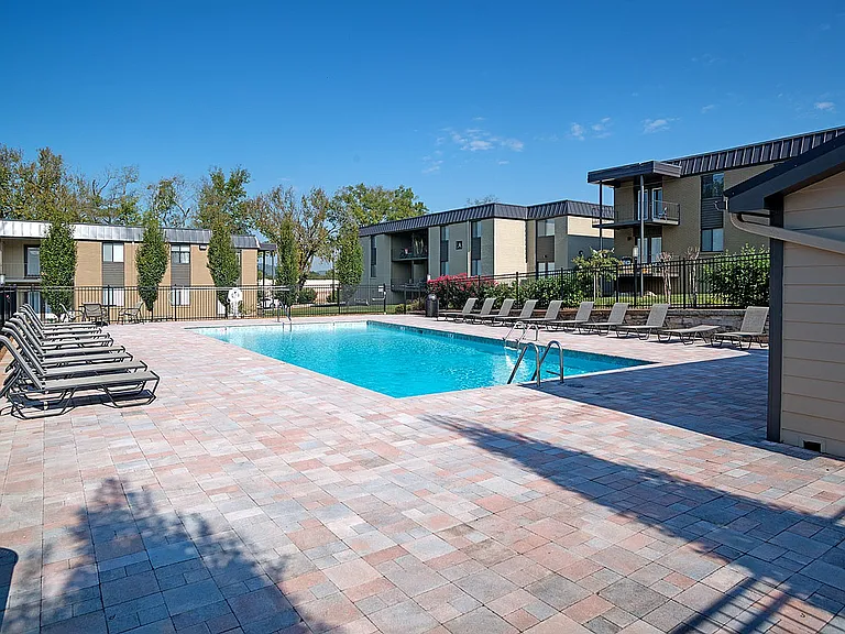 Relax by the sun-drenched pool at this modern apartment complex.