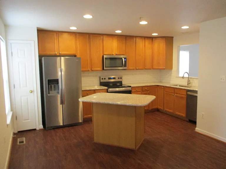 Eat in kitchen with corian countertops, tile backsplash, and all stainless steel appliances