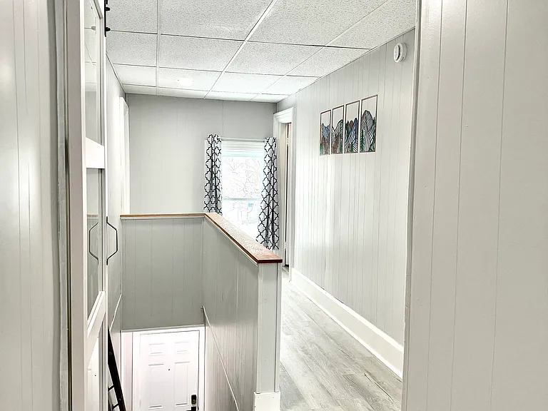 The hallway and stairs leading up to the unit are filled with plenty of natural light, creating a bright and welcoming atmosphere as you enter the space.