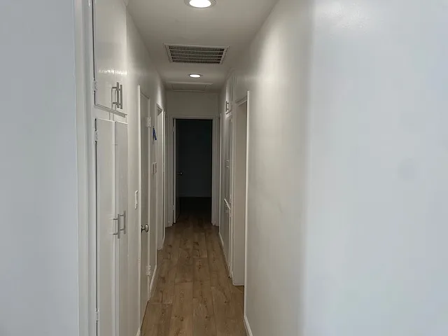 Hallway to powder room, 3 bedrooms, and 2 other bathrooms.