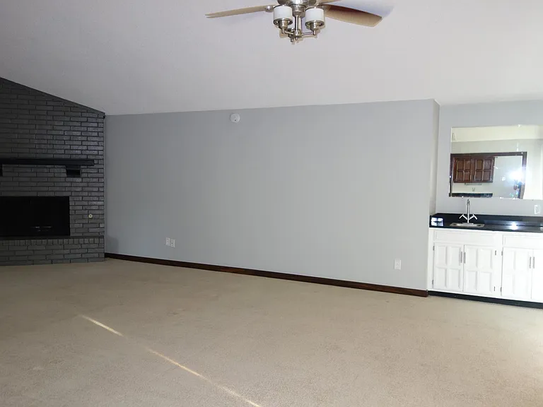 Large vaulted and beamed living room. Bar area in right corner w/sink and storage! *New LED rescessed Lights being installed*