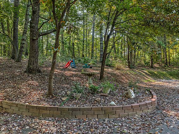 Forest area to left of 2 carport.