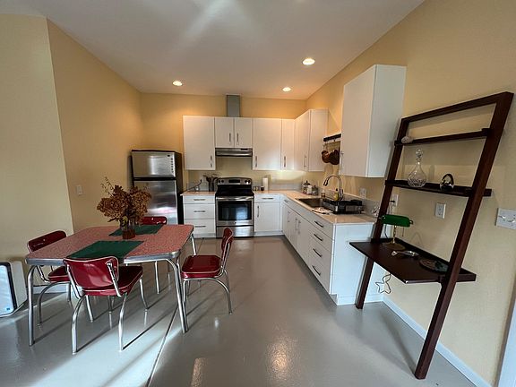 Kitchen with electric stove and vent hood.