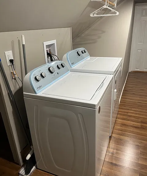 Laundry side of laundry/pantry room with two clothes hanging rod stations and storage behind