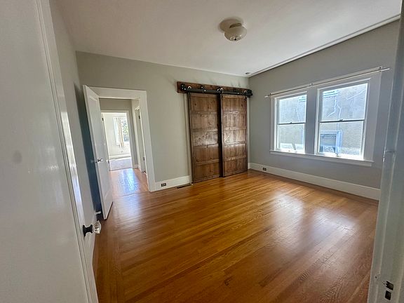 Main bedroom view from living room door access. Closet has wood barn doors.