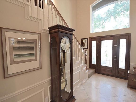 This welcoming foyer lets loads of sunlight in through the transom and leaded glass doors.