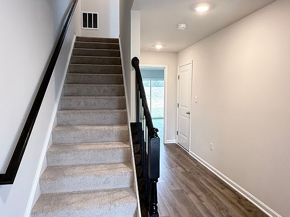 Front Foyer - Hallway leading to Den/Office on left, Staircase to Second Floor on right. Garage Door on right side before Den/Office