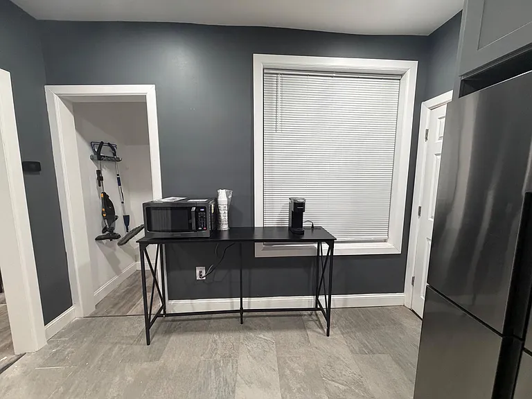 Dedicated kitchenette/coffee nook with a full-size refrigerator, microwave station, and a window for ventilation.
