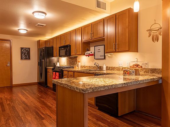 Kitchen includes high-end appliances; gas range and oven, full-sized refrigerator, dishwasher, and an island/bar.