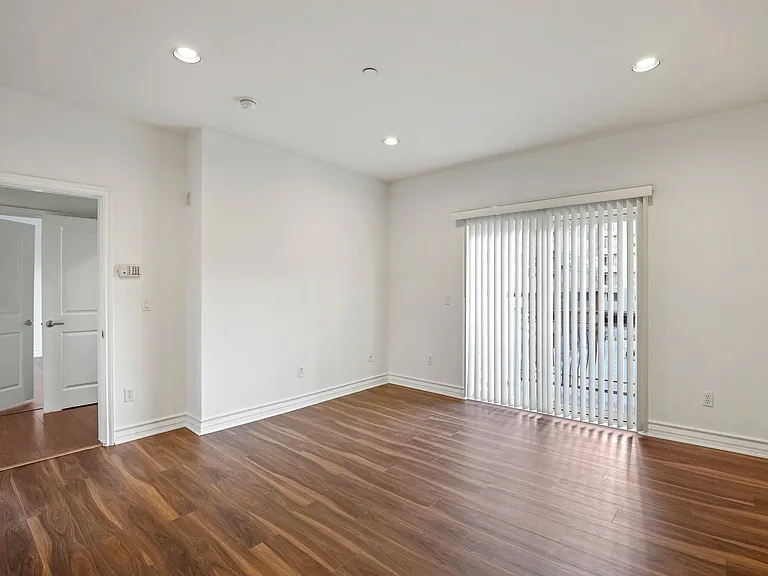 Living Room Space with In-Suite Alarm System, Recess Lighting, and Balcony
