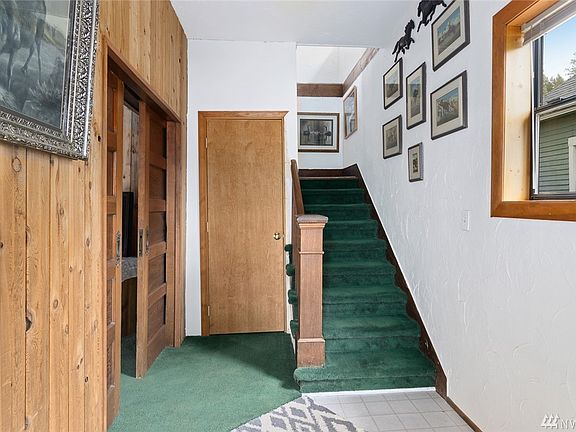 Nice detail in the entry. The stairs could be refinished and would be beautiful. Cool sliding doors on the left lead into the living room.