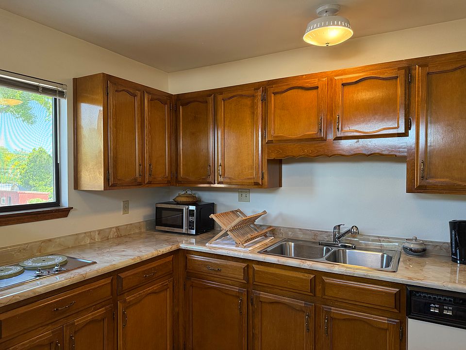 The kitchen is equipped with kitchen basics, an electric kettle, a microwave, and a dishwasher.