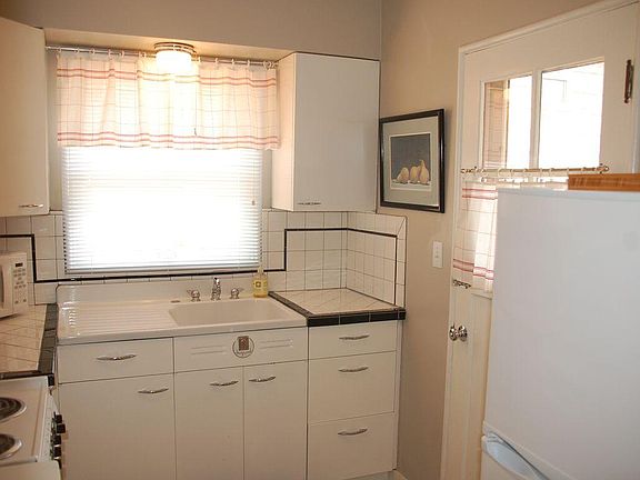 Quaint kitchen with tile and vintage metal cabinets.