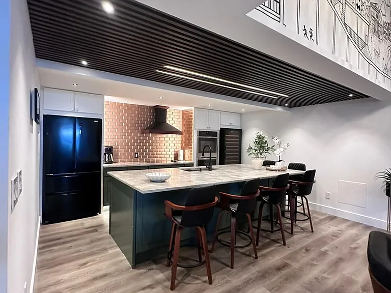 Sophisticated kitchen featuring upscale finishes and a modern refrigerator.