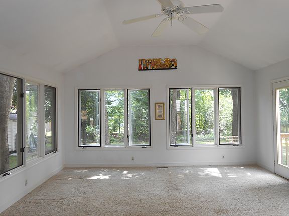 Huge Florida room looks out onto large fenced backyard and patio