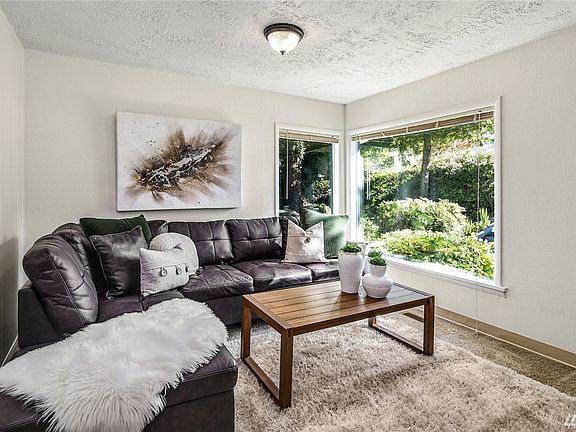 Living room with big picture windows for plenty of sunshine.