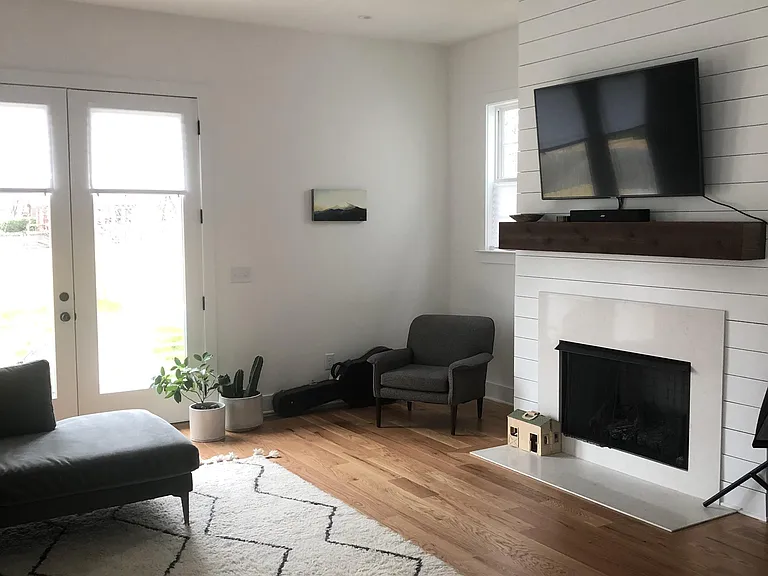 Spacious living room with gas log fire place, lots of light and open to kitchen dining area.