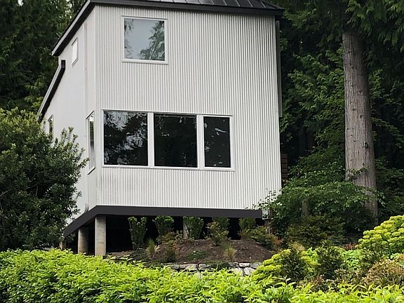 The front of the cottage sits high above Rich Passage for sweeping views of the water and passing ships.