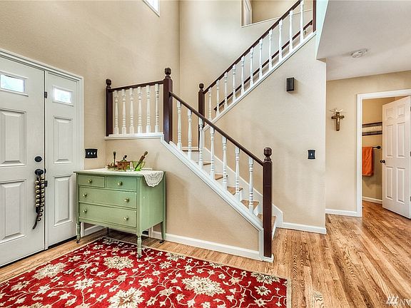 Spacious 2 story entry with open rail staircase. Look at these gorgeous hardwood floors that are in every room except the laundry on the main floor and then continue on the stairs and upstairs hallway. There are 6 panel doors, new baseboards and wood wrapped windows.