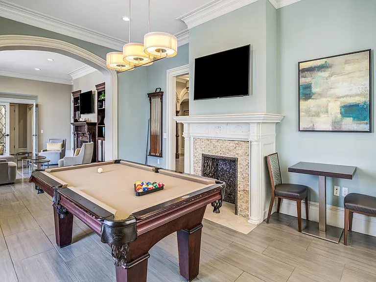 Luxurious entertainment room with elegant pool table, modern fireplace, and stylish seating area.