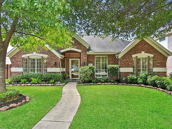 This stately manor with red brick and white limestone accents welcomes you as you make your way up the path lined with lush landscaping to the beautiful solid wood and leaded glass front door.