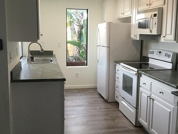 Kitchen with microwave, stove, dishwasher, fridge, sink disposal