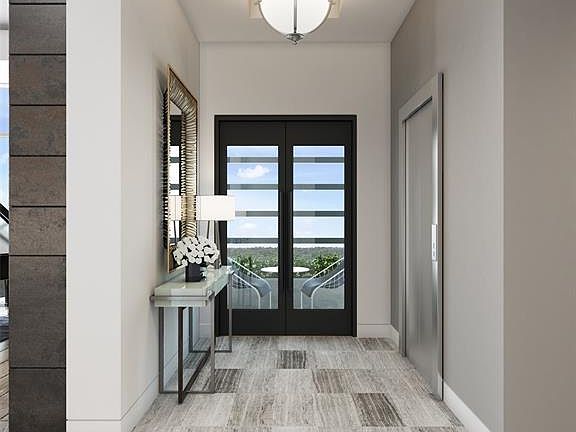 Foyer of a residence with direct elevator access to right and view through door to one of the home's garden terraces.