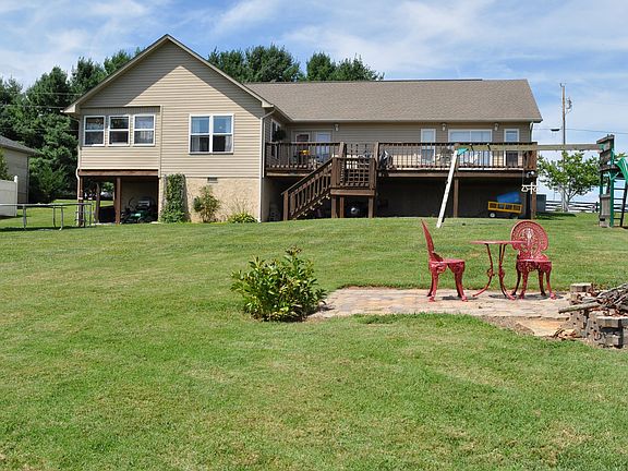 Back of home with fire pit area