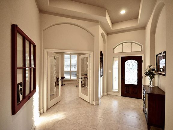 High ceilings look towards study with glass doors