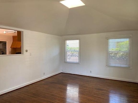 Spacious living room with wood floors, skylight, lots of light