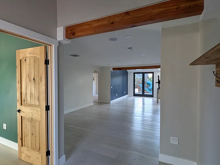Going through the font door, the office(3rd bedroom) is on the left. Living room is past the beam.