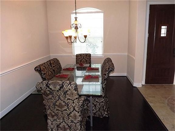 Elegant entertaining is achieved in the stylish dining room with, chair rail trim, tall windows and wood flooring