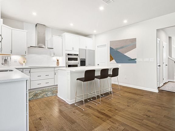 Bright Open Kitchen with elegant engineered wood flooring.