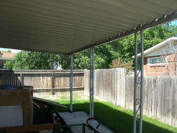 Fenced backyard with awning over patio