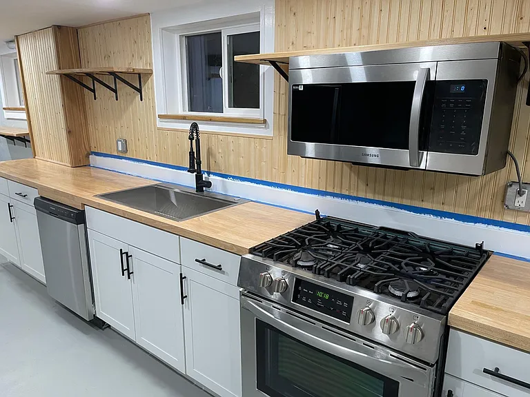 Oil rubber butcher block countertops, soft close cabinets with open upper shelves and ultra clean concrete floors.