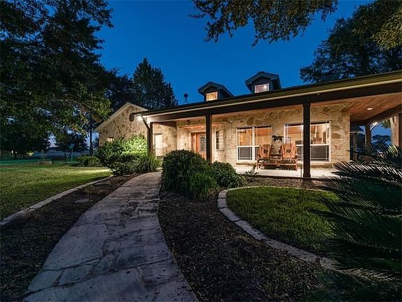 Wrap around porch with flagstone deck has custom wood ceilings with recessed lighting.