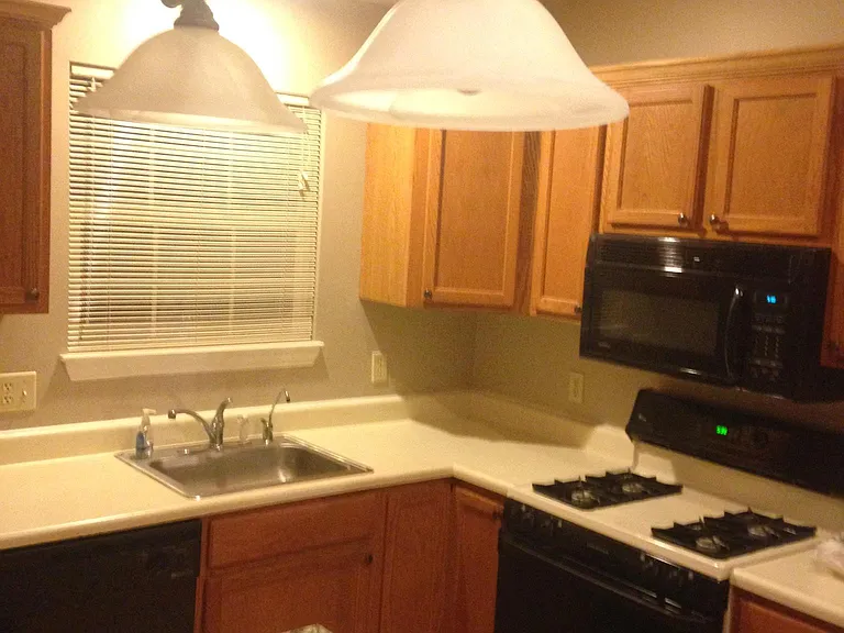 Kitchen showing appliances and window facing rear yard.
