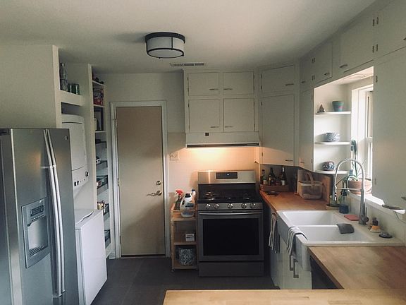 Spacious kitchen includes L shaped counter, refrigerator, full size stackable washer and dryer and full height pantry with extensive storage capability.