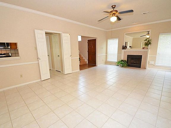 The living room features a cozy fireplace w/natural stone surround & built-in mirror w/elegant trim. A window on each side allows for plenty of natural light! It's the perfect focal point!