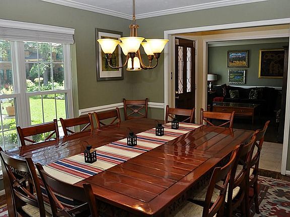 A grand formal dining room on other side of the formal living room with Hunter Douglas wood blinds a
