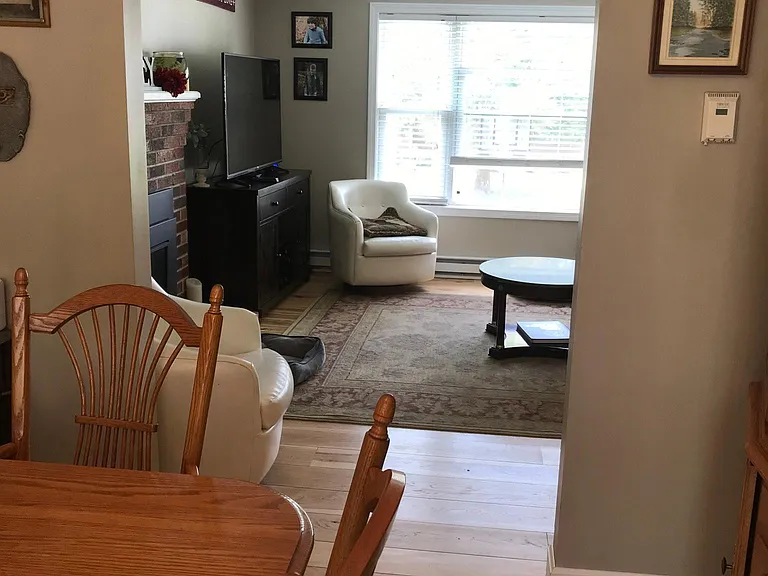 Dining-room with hardwood floor looking into living-room.