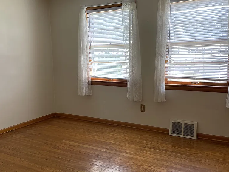 Largest bedroom includes three large windows and ceiling fan