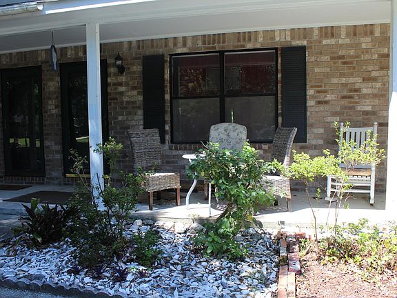 view of front of unit, seating on front porch so you can be out of the sun