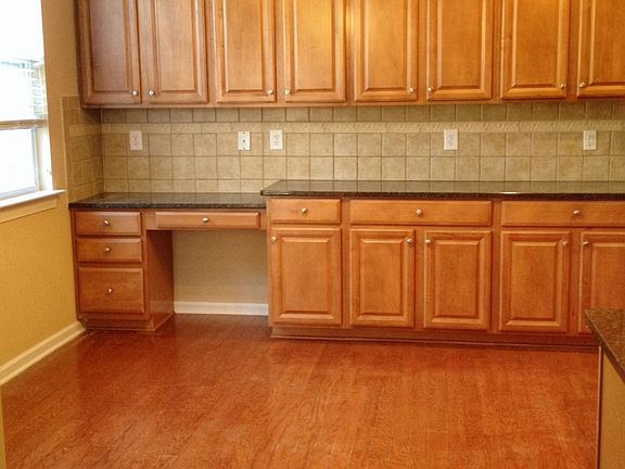 Sunny, large kitchen has eat-in area, desk, and abundant cab
