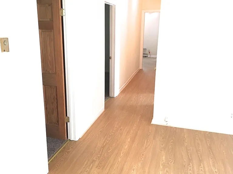 Hallway from living room kitchen. Two bedrooms on left, one on right.
